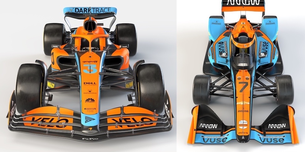 A side-by-side comparison of two race cars. On the left is a Formula 1 car with "DARKTRACE" branding, predominantly orange with blue accents and featuring sponsors such as "Dell" and "VELO". It has a low, sleek profile with complex aero elements and tightly packaged bodywork. On the right is an IndyCar, labeled with the number 7 and "mission" branding, with a similar orange and blue color scheme but a visibly different aerodynamic setup, including a bulkier air intake above the driver's head and simpler side pods. Both cars have large, slick racing tires and are designed for high-speed circuit racing, showcasing the unique design philosophies of their respective racing series.