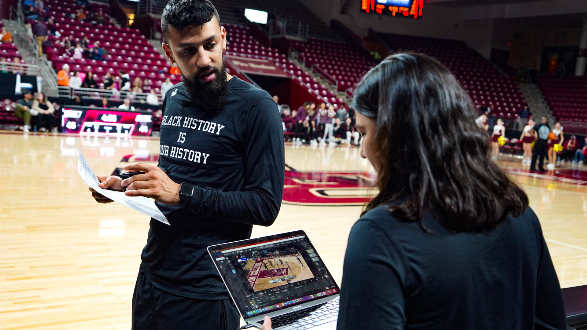 In einer dynamischen Spielfeldumgebung nutzt ein Teammitglied des Boston College die Catapult Pro Video Focus-Plattform auf einem Laptop, um Basketball-Videoanalysen in Echtzeit durchzuführen. Der Live-to-Bench-Workflow ist in Aktion und zeigt, wie eine sofortige Nebenanalyse Teams in die Lage versetzt, schnelle strategische Entscheidungen zu treffen.