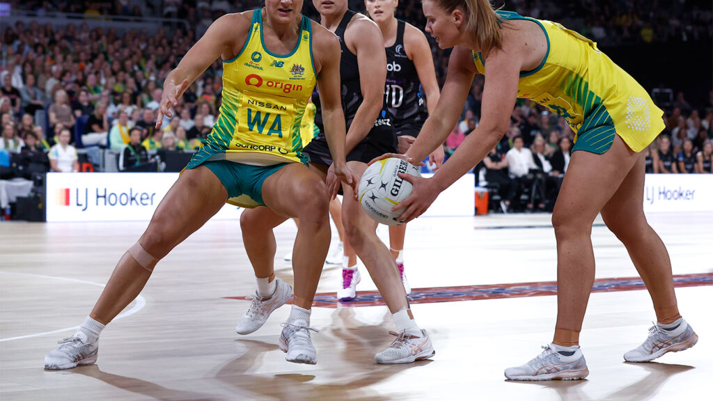 Des joueurs de netball dans une bataille tendue sur le terrain, mettant en évidence les mesures d'agilité et de performance essentielles à l'analyse sportive