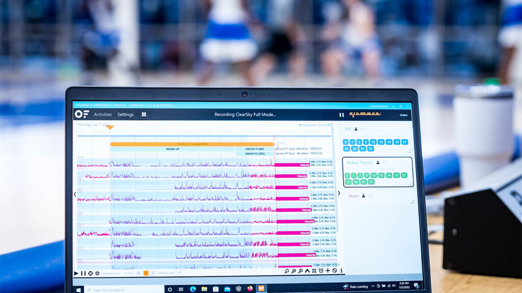 Computadora en un banco deportivo que muestra datos analíticos en tiempo real durante una sesión de entrenamiento, lo que ejemplifica el uso de la tecnología en los deportes.