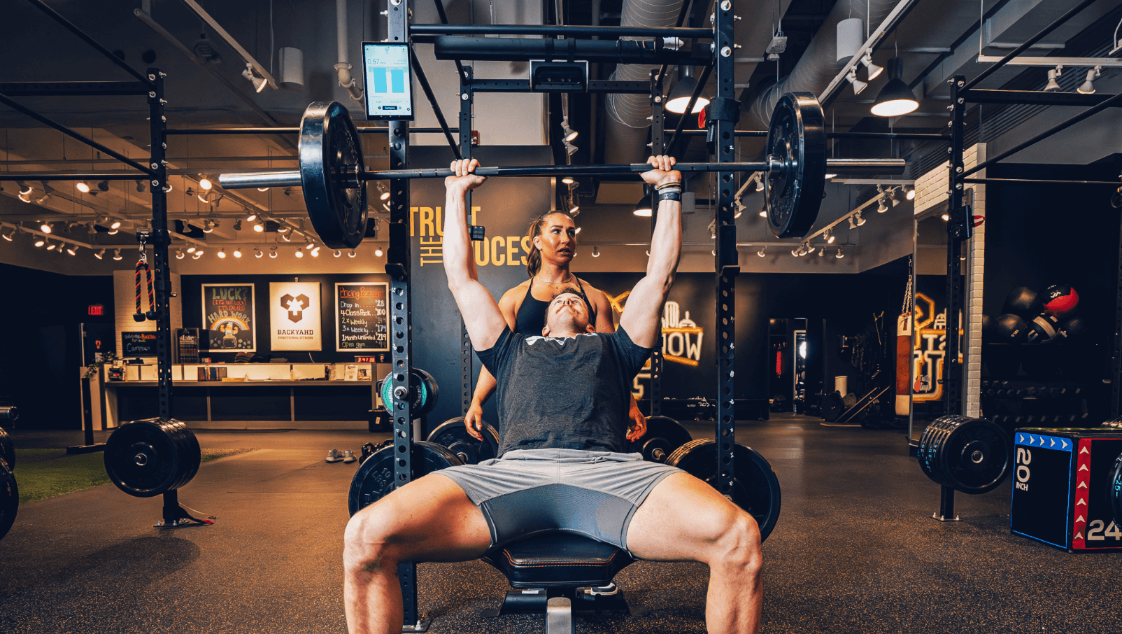 Người đàn ông đang nâng tạ. Perch và một người phụ nữ nhìn thấy anh ta